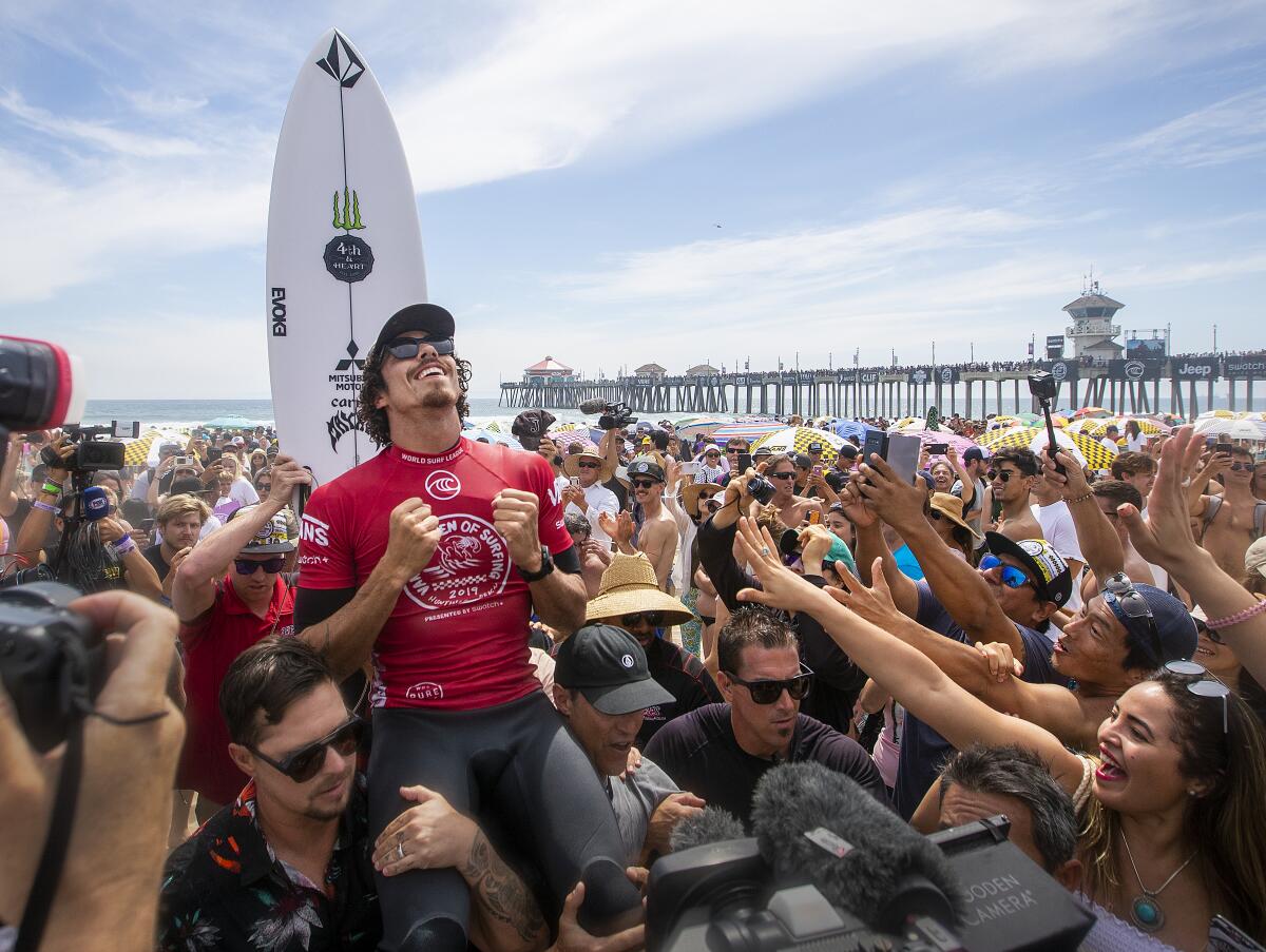 Fans cheer as Yago Dora celebrates winning the men's title at the U.S. Open of Surfing.