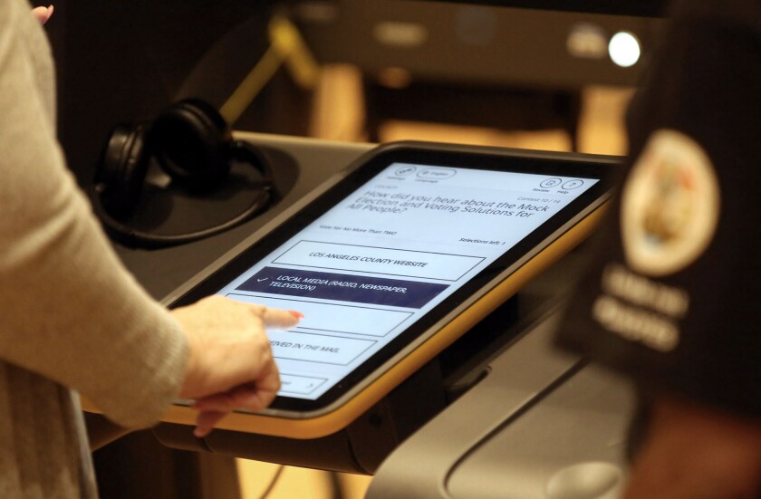 Mary Mullen, of Glendale, uses a touch screen to place her vote during a mock-election event in November that showcased new voting technology rolling out across L.A. County this year. A demo center opened at the Glendale police station this month, giving potential voters additional opportunities to try out the new computer-aided system.