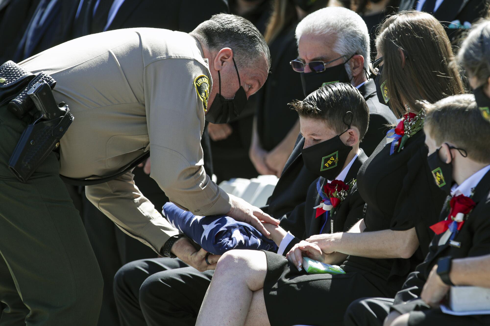 Los Angeles County Sheriff Alex Villanueva presents flag to Landen Albanese, the 11-year-old son of Deputy Thomas Albanese 