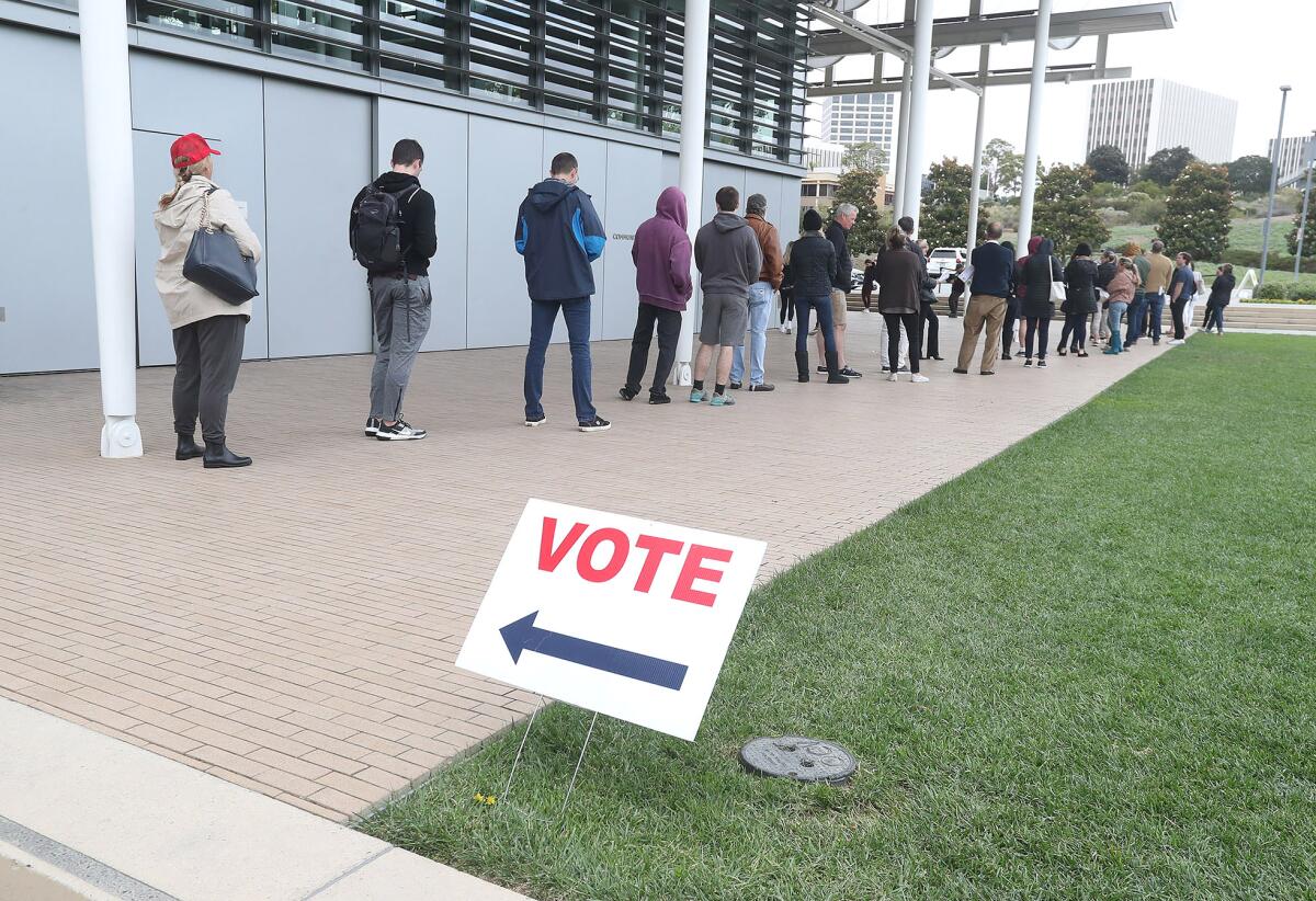 Voters wait in line to cast their ballots on Election Day at Newport Beach City Hall.