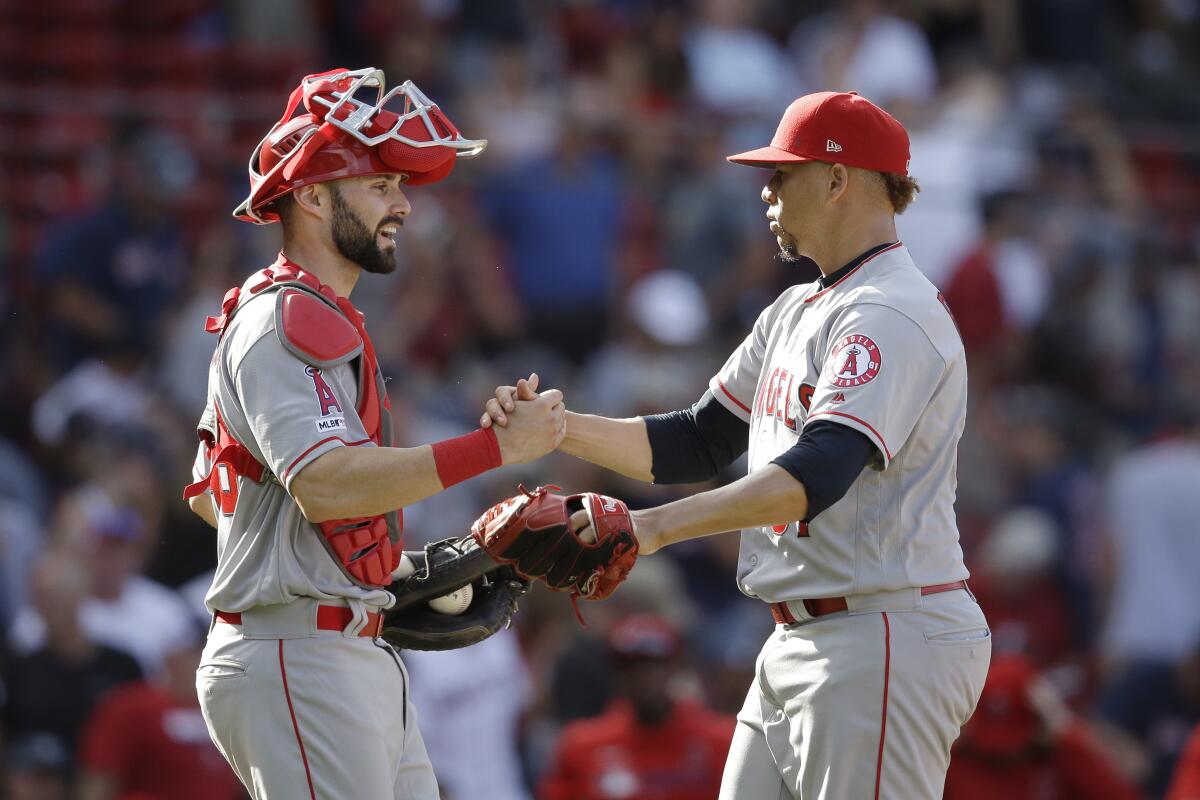 Angels' Max Stassi, left, and Hansel Robles celebrate their win over the Boston Red Sox on Aug. 11 in Boston.