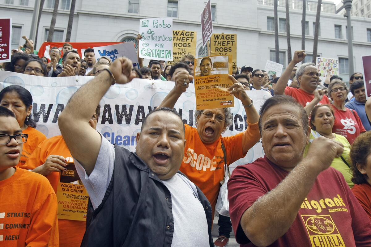 Handyman Axel Paredes chants during a press conference by the Los Angeles Coalition Against Wage Theft on the steps of Los Angeles City Hall on Tuesday in Los Angeles. The coalition held the news conference to announce a City Council motion aimed at criminalizing wage theft.