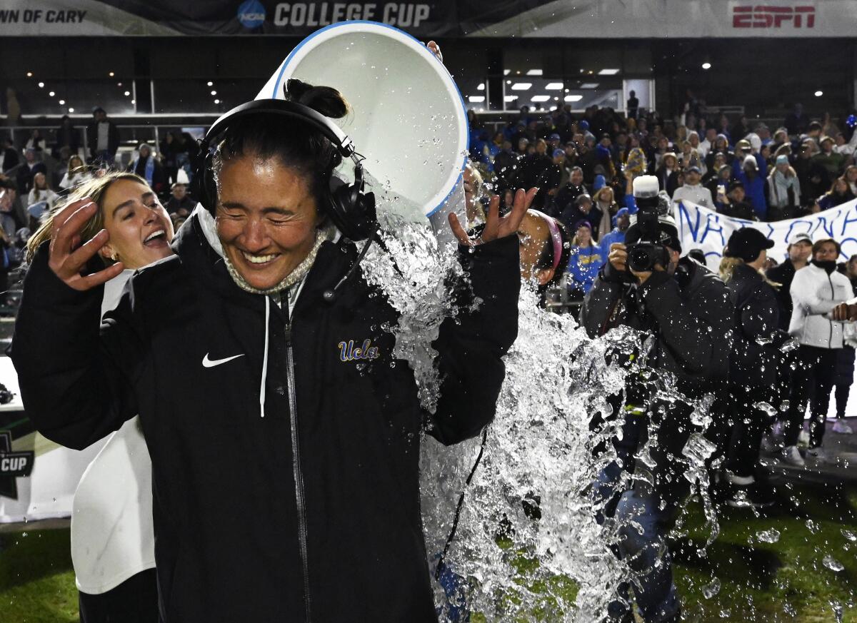 UCLA women's soccer coach Margueritte Aozasa is doused in ice water after the Bruins' comeback victory over North Carolina.