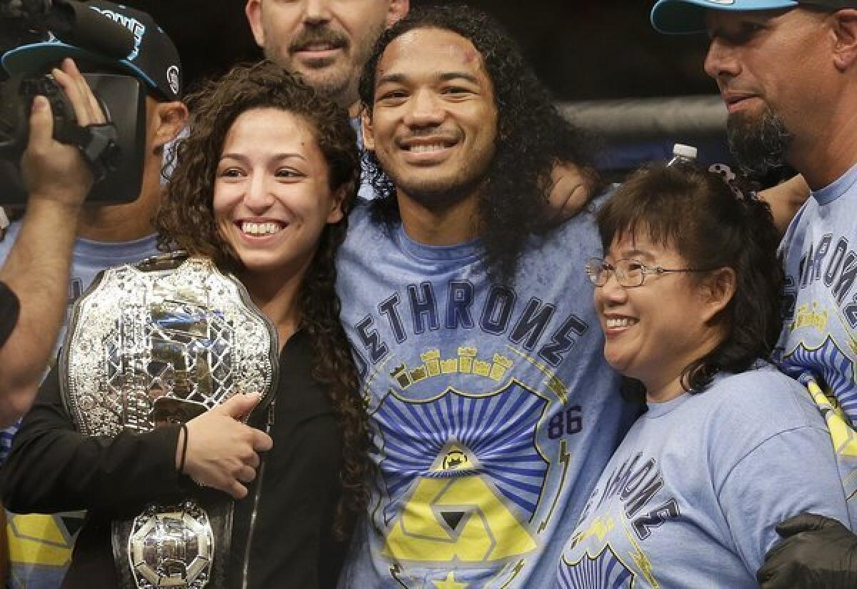 Benson Henderson celebrates with his fiancee, Maria Magana, and mother, Song Henderson, after a split-decision victory over Gilbert Melendez in a lightweight championship bout at "UFC on Fox 7" in San Jose.