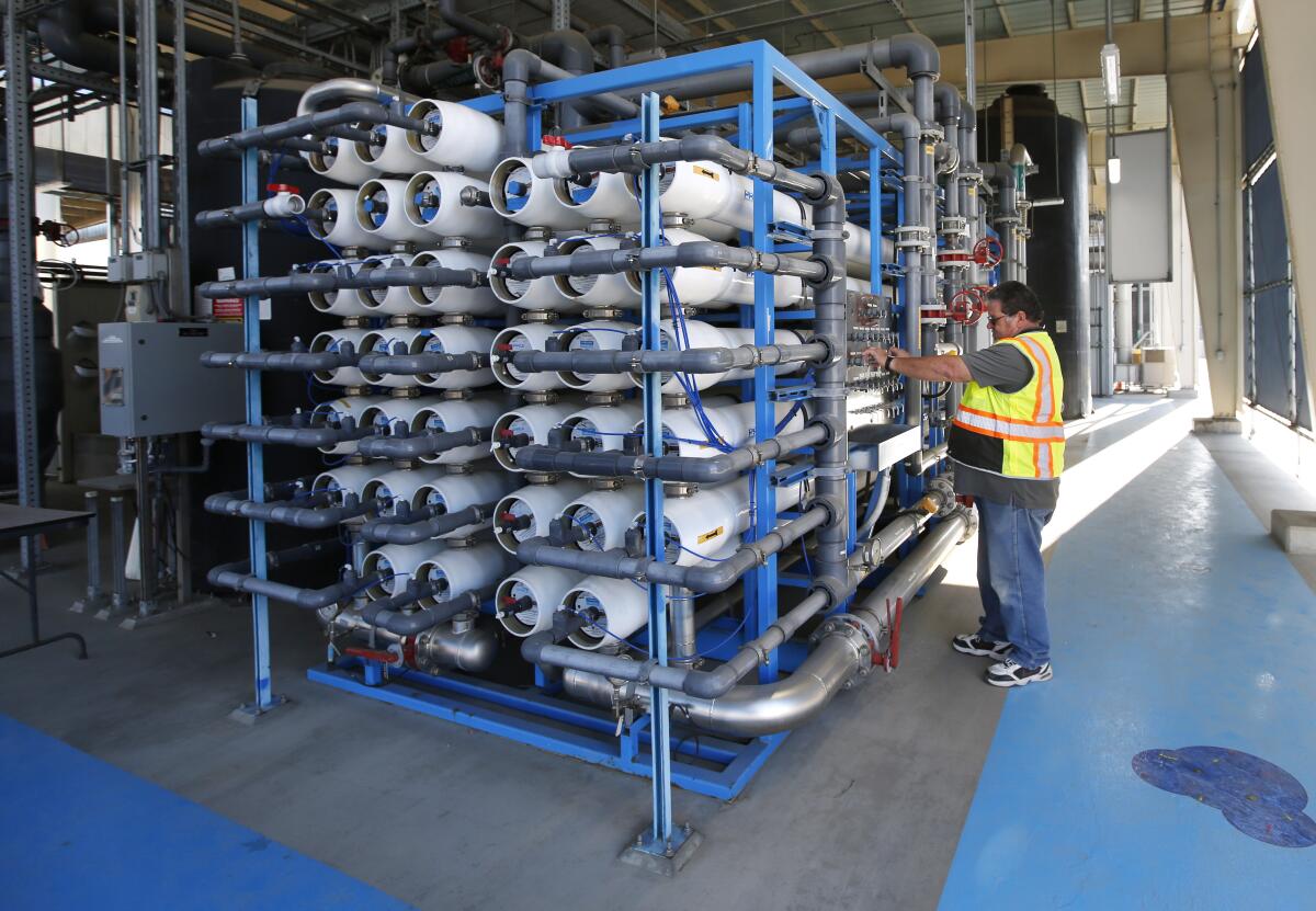 Senior plant tech supervisor David Mills looks over reverse osmosis filters at the Pure Water Demonstration Facility.