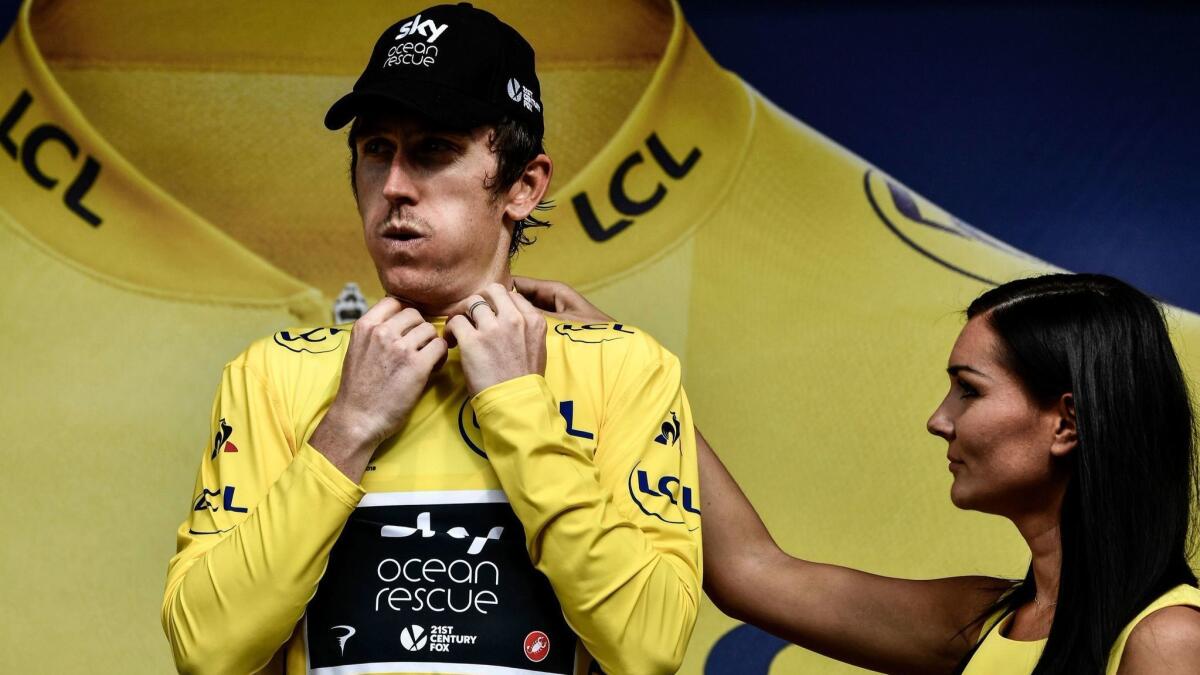Geraint Thomas puts on the overall leader's yellow jersey after the 19th stage of the the Tour de France on July 27.