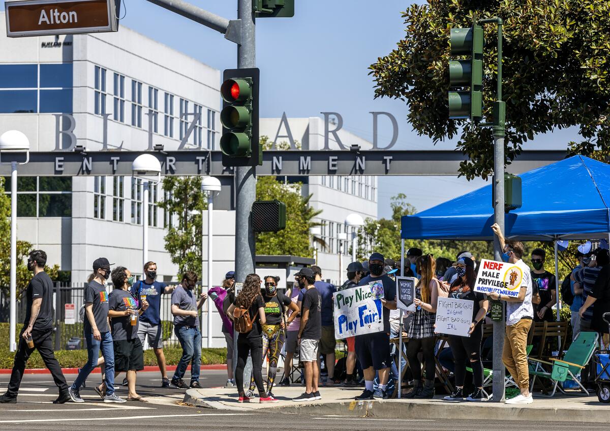 Some Activision Blizzard employees carry signs after their walkout in July.