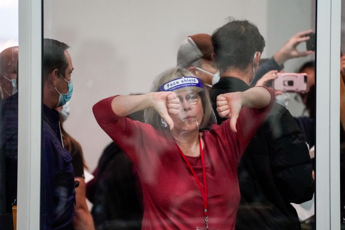 A woman gives a double thumbs down at a ballot-counting center in Detroit.