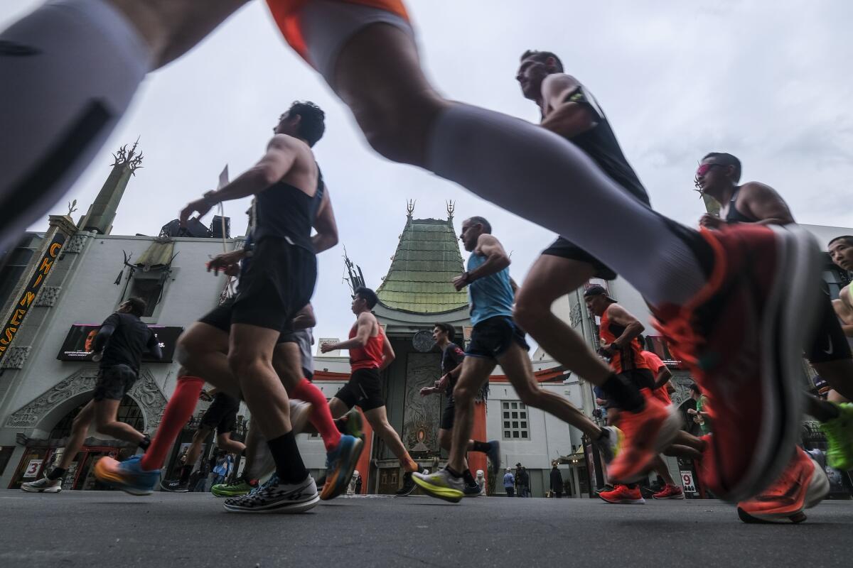 Runners run past TCL Chinese theater along Hollywood Boulevard during the 38th L.A. Marathon