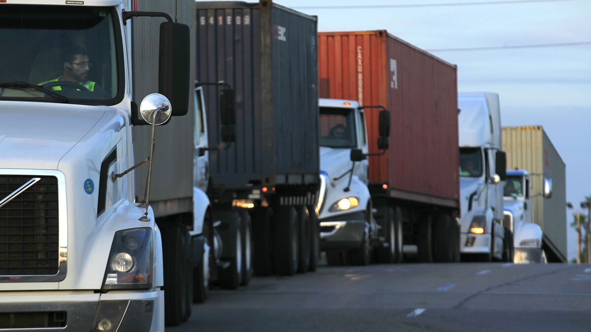 Trucks wait in line to take cargo to a pier in Long Beach in 2014.