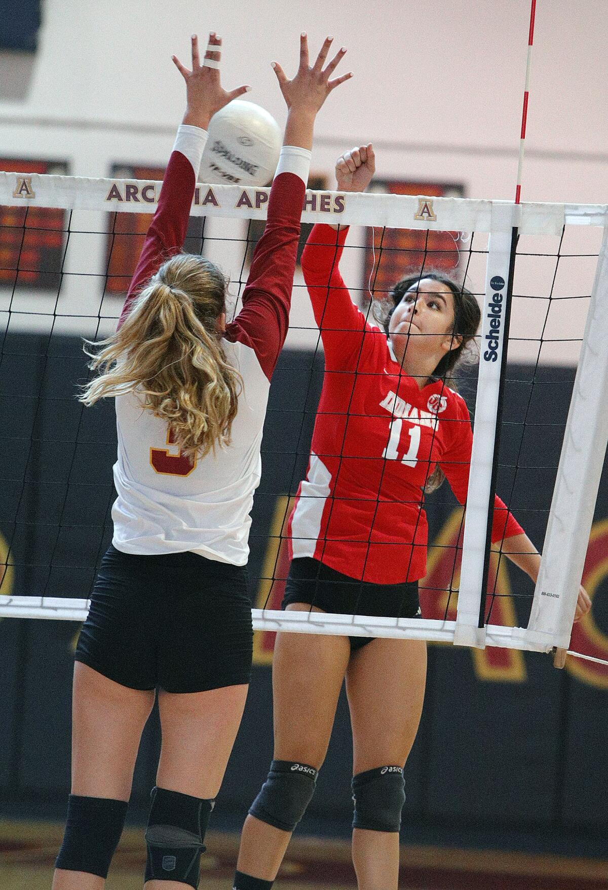 Burroughs' Catie Virtue hits the ball past Arcadia's Ashley Marron in a Pacific League girls' volleyball match at Arcadia High School on Thursday, September 19, 2019. (Tim Berger / Staff Photographer)