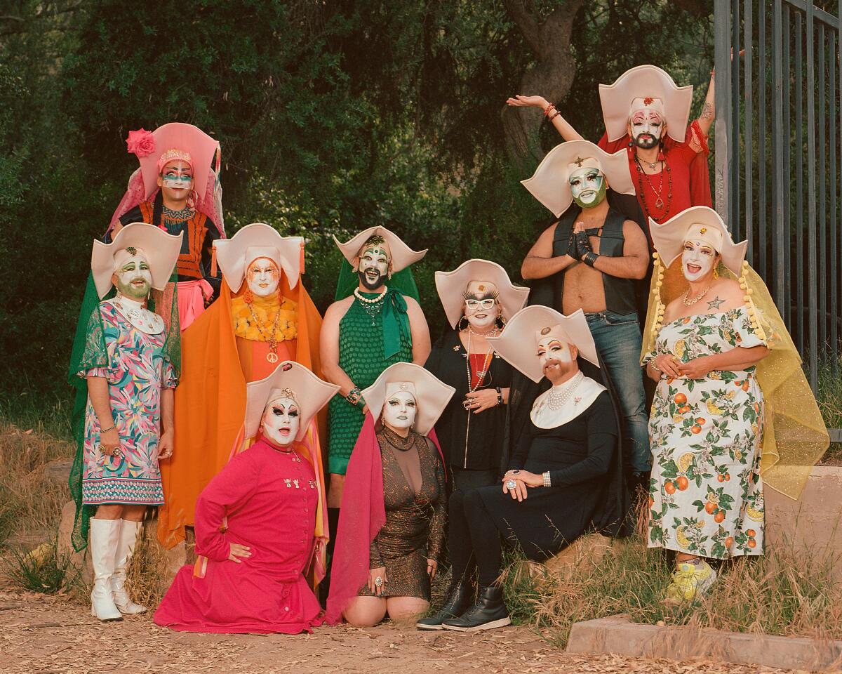 A group dressed in white makeup and nun attire pose for a portrait outside.
