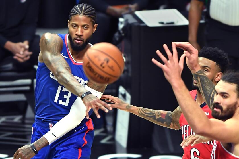 Clippers' Paul George gets a pass off in front of Pelicans Nickeil Alexander-Walker, center, and Steve Adams