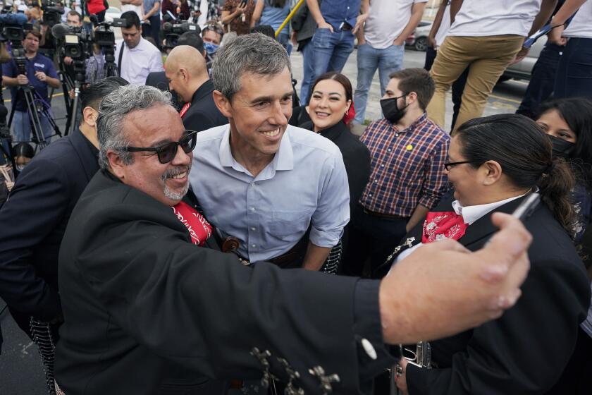 Democrat Beto O'Rourke, center, poses for photos with members of a Mariachi band during a campaign stop, Tuesday, Nov. 16, 2021, in San Antonio. O'Rourke announce Monday that he will run for Texas governor. (AP Photo/Eric Gay)