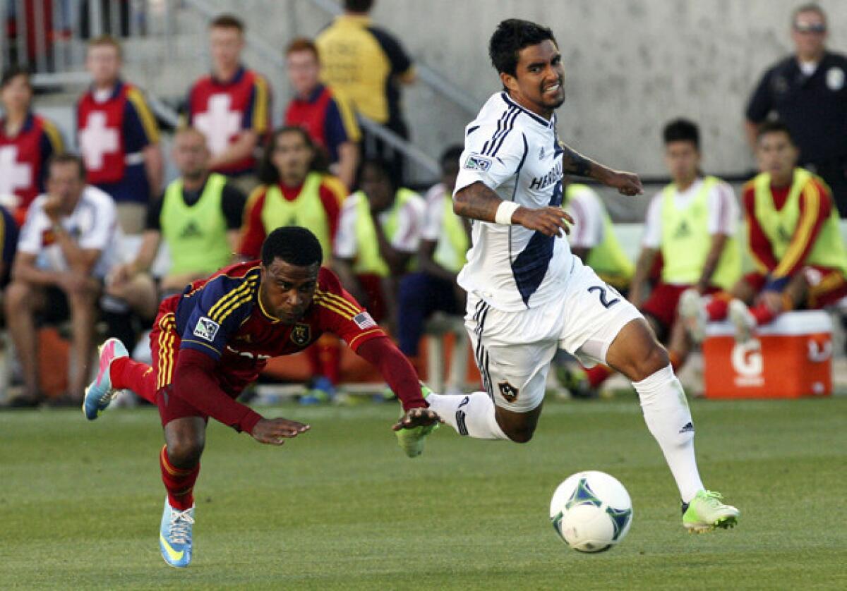 Real Salt Lake forward Robbie Findley, left, loses his footing as he and Galaxy defender A.J. DeLaGarza (20) chase down the ball during the first half of a game on June 8.
