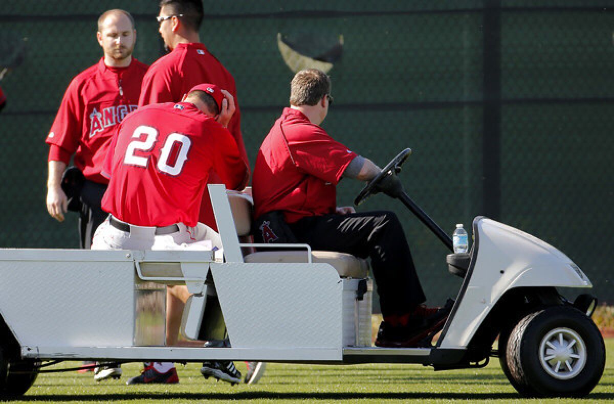 Angels pitcher Mark Mulder (20) is carted off the field after injuring his Achilles' tendon during a spring training workout on Saturday.