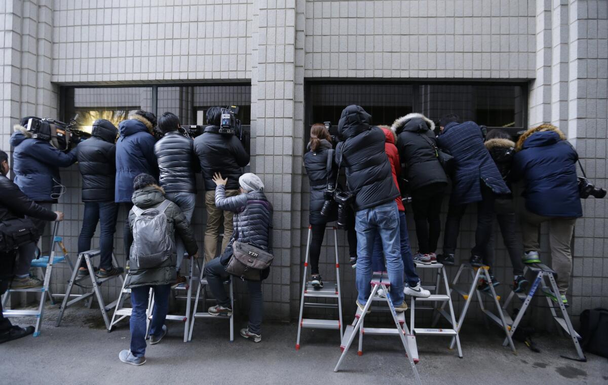 Members of the media try to get pictures of a bus carrying Heather Cho, a former vice president of Korean Air, at a hearing in her "nut rage" case in Seoul on Feb. 12.