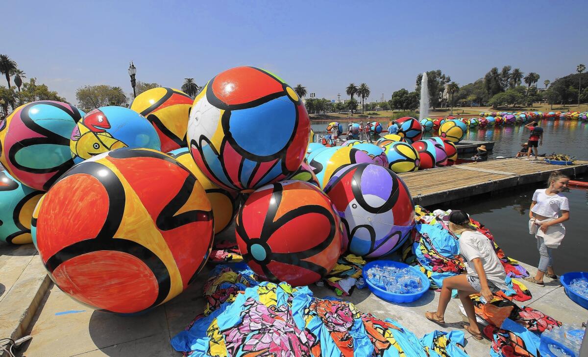 Volunteers install 3,000 inflated vinyl spheres in the water at MacArthur Park. The project is the brainchild of brothers Bernie and Ed Massey.
