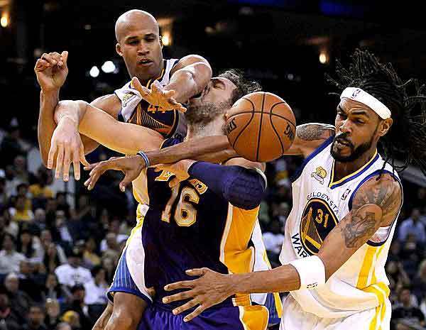 Lakers power forward Pau Gasol, who finished with a triple-double, gets the worst of it as he's fouled by Warriors forward Richard Jefferson and center Mikki Moore in the second half Wednesday night in Oakland.