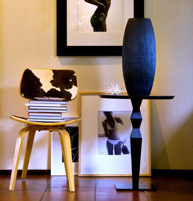 In the entryway leading to the living room: Walter Chin photography, books stacked on a '50s cowhide chair and a table by Christian Liaigre.