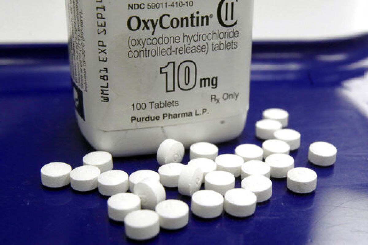 OxyContin pills lie next to a pill bottle.