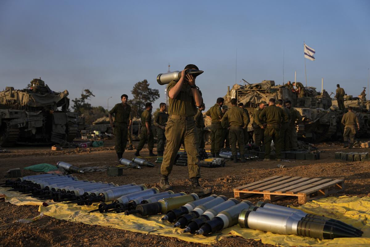 Soldados israelíes cargan proyectiles en un tanque en una zona del sur de Israel próxima a Gaza,