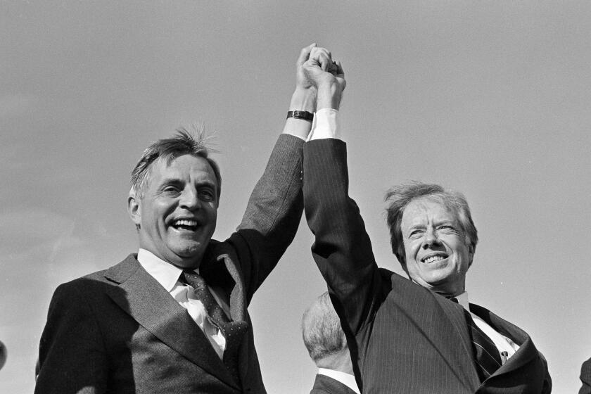 President Jimmy Carter, right, and Vice President Walter Mondale share a victory salute at the Akron-Canton Municipal Airport in Akron, Ohio, Nov. 3, 1980. They addressed a rally of about 4,000 people before taking off for another campaign stop. (AP Photo/Jim Wells)