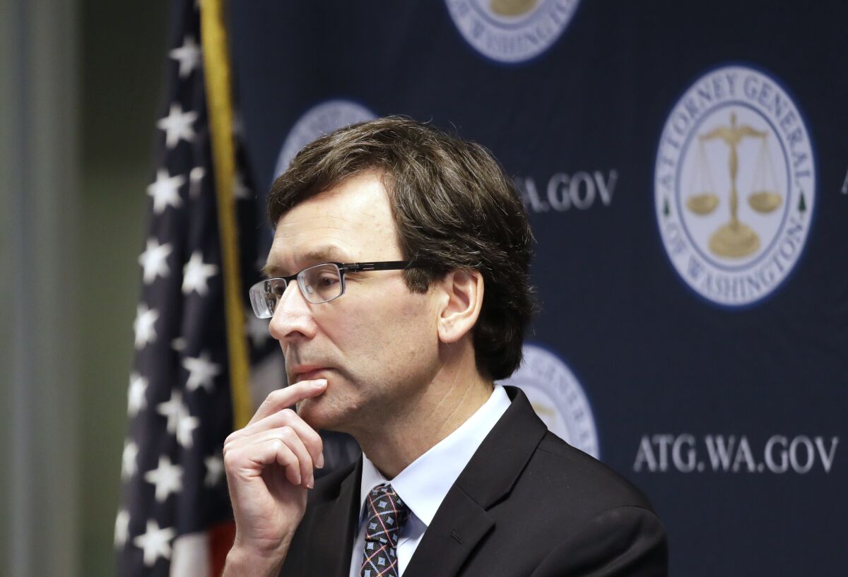 FILE - Washington state Attorney General Bob Ferguson looks on during a news conference in Seattle on Dec. 17, 2019. Ferguson rejected a half-billion-dollar settlement offer, and now he's taking the state's case against the nation's three biggest drug distributors to trial Monday, Nov. 15, 2021. He says they must be held accountable for their role in the opioid crisis. (AP Photo/Elaine Thompson, File)