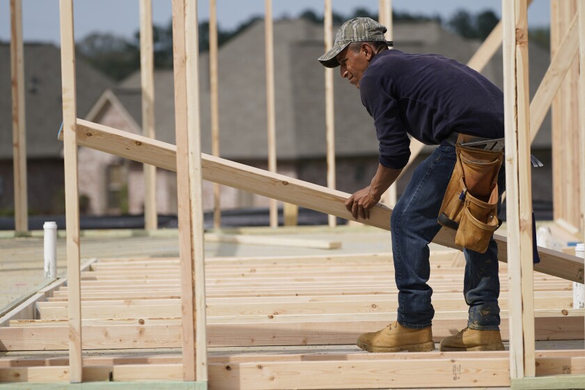 A carpenter aligns a beam for a wall frame at a new house site in Madison County, Miss., Tuesday, March 16, 2021. U.S. home construction fell by a bigger-than-expected amount in April but the drop came after housing had risen to the highest level in 15 years. The Commerce Department said Tuesday, May 18, that construction dropped 9.5% in April to a seasonally adjusted annual rate of 1.57 million units. % in April to an annual rate of 1.76 million units, a good sign that the April dip in construction will be temporary. (AP Photo/Rogelio V. Solis)