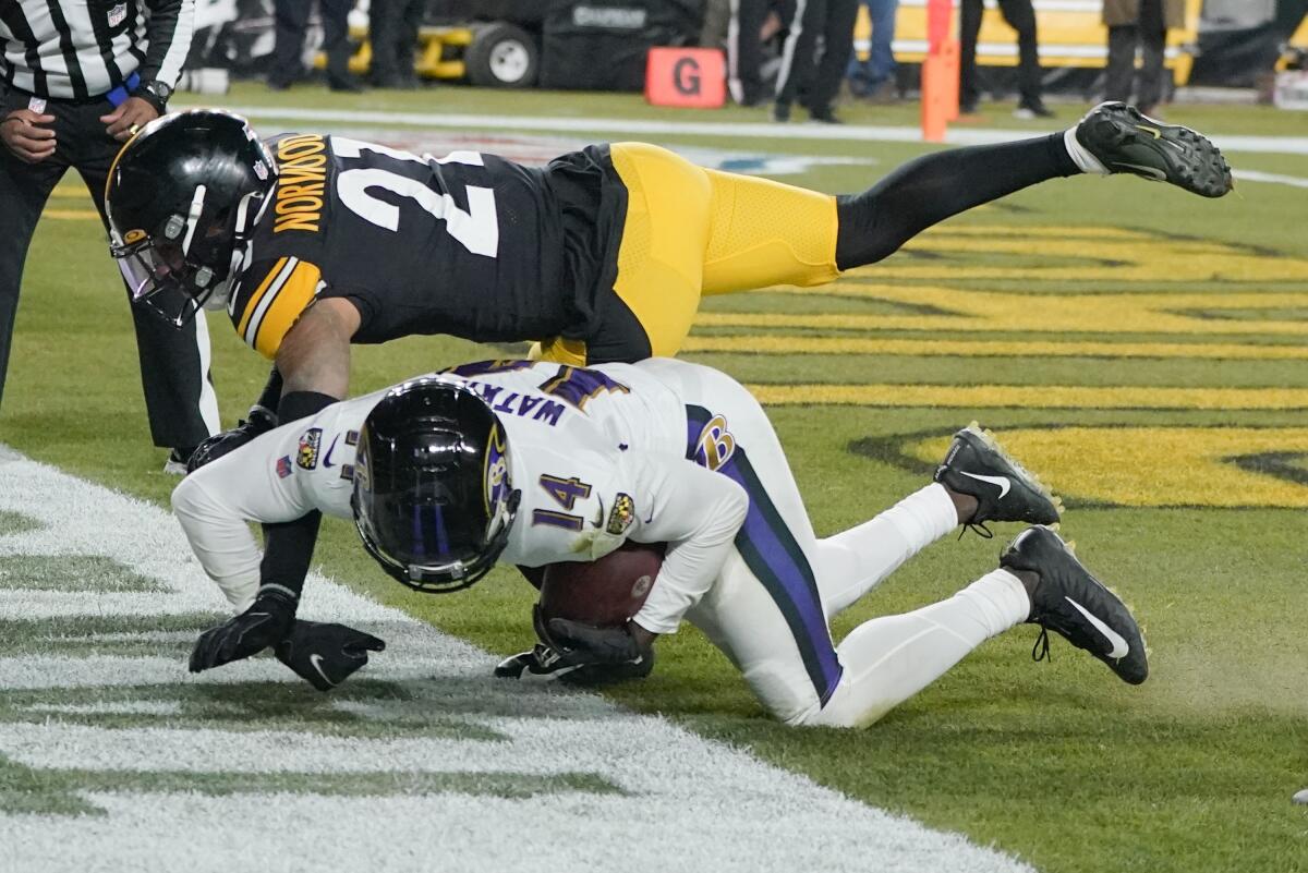 Baltimore receiver Sammy Watkins falls after making a touchdown catch as Pittsburgh cornerback Tre Norwood dives over him.