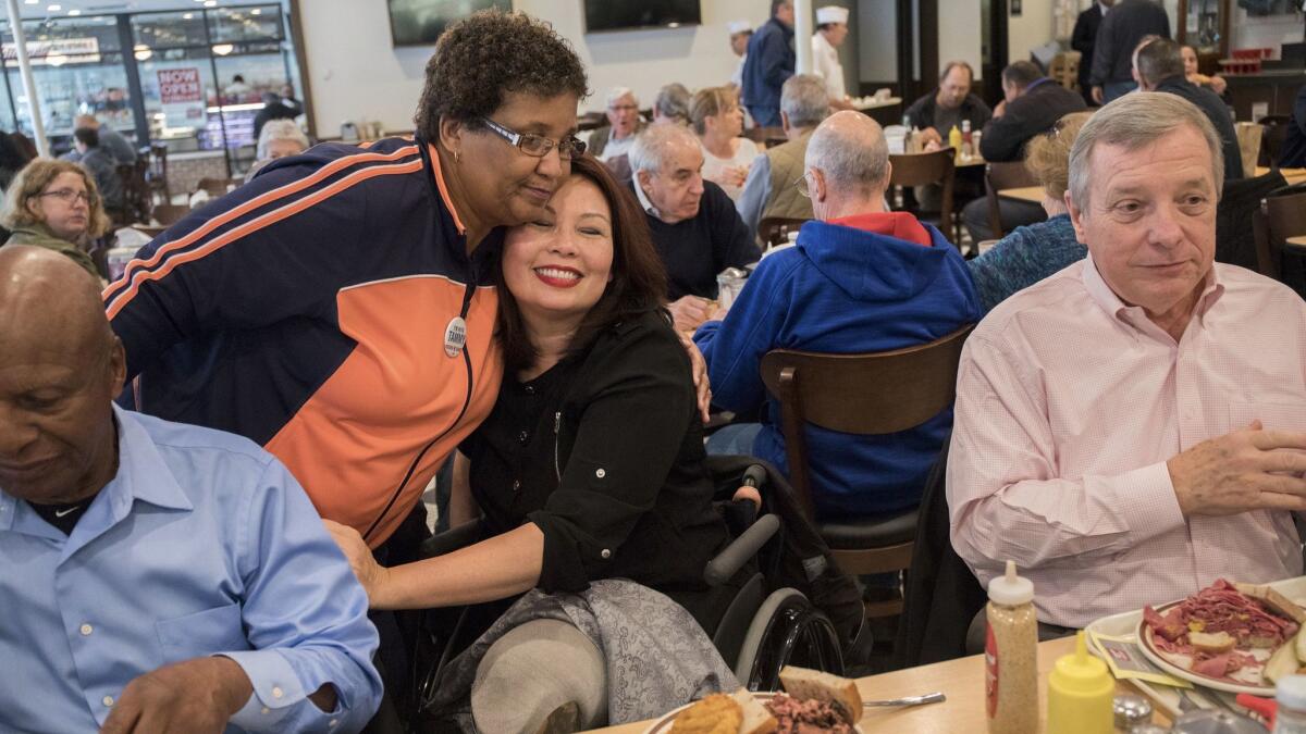 Tammy Duckworth, center, candidate for U.S. senator for Illinois, gets a hug from supporter Demetria Puckett, 62, during lunch with Secretary of State Jesse White, left, and Sen. Richard J. Durbin on Tuesday in Chicago.