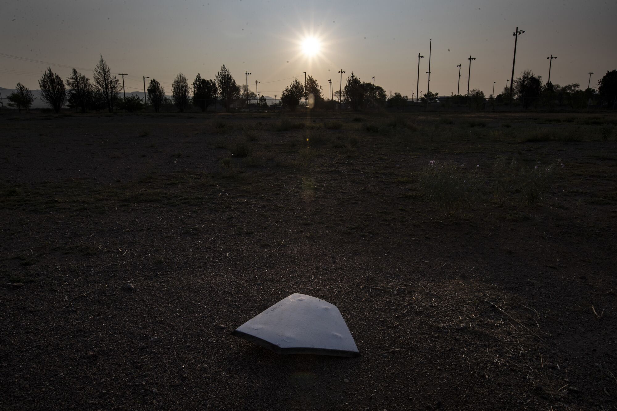 Home plate is unmoored from the batters box on a disused baseball diamond at the Lordsburg Special Events Center