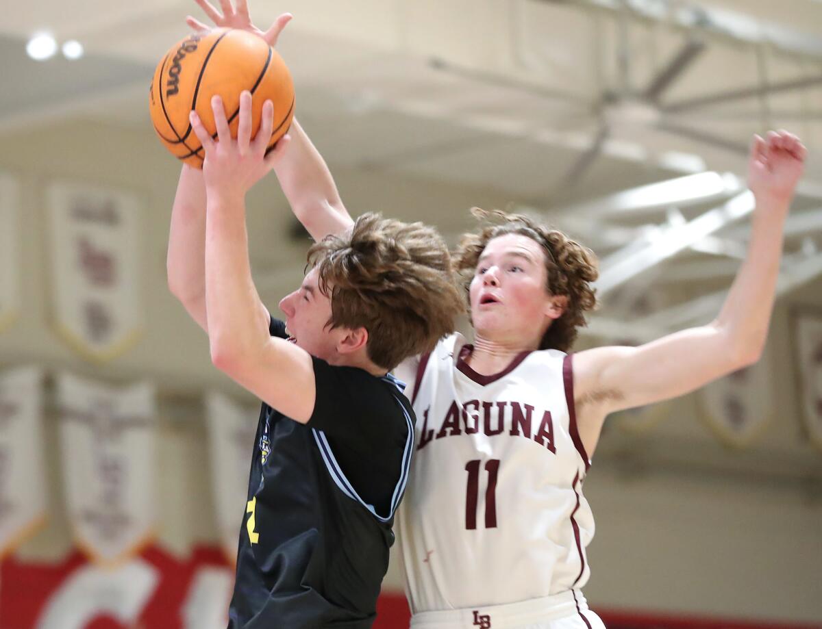 Marina's Mark Yeager drives past Laguna's Mack Thompson for a lay-up during Wednesday night's game.