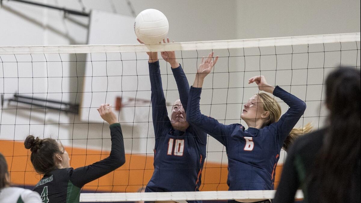 Pacifica Christian Orange County High's Allyson Scharrer, left, and Casie Carlson, shown blocking a shot against Orangewood Academy on Oct. 19, helped the Tritons sweep Los Angeles Covenant Academy in the first round of the CIF Southern Section Division 9 playoffs on Thursday.