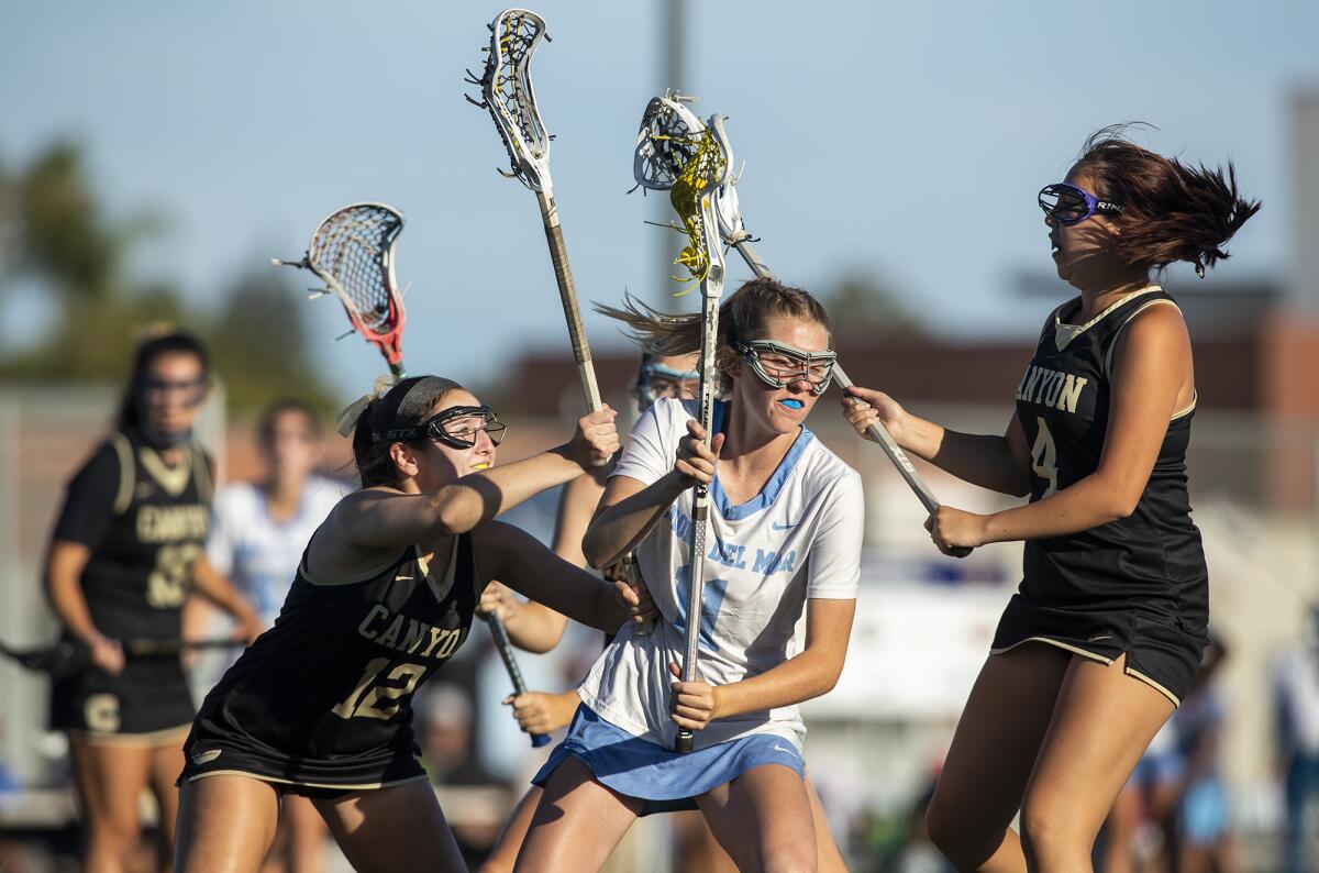 Corona del Mar's Abby Grace, center, battles with Canyon's Lindsay Parsons, left, and Calle Bandong on June 9.
