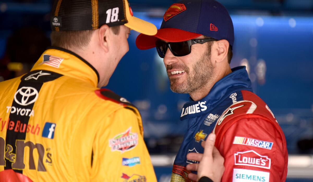 NASCAR drivers Jimmie Johnson, right, and Kyle Busch, chat in the garage area during practice Friday for the Sprint Cup Series Auto Club 400.