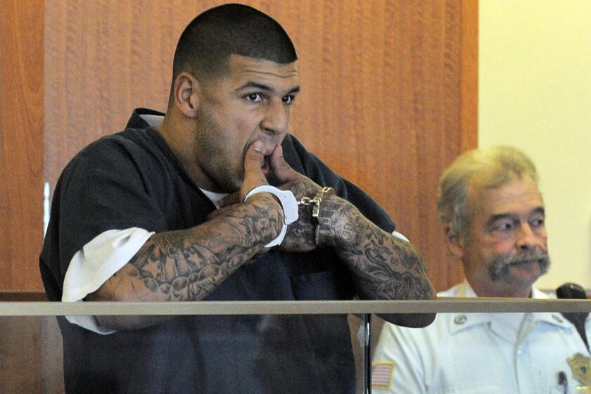 Former Patriots tight end Aaron Hernandez wipes his mouth during his bail hearing on Thursday.