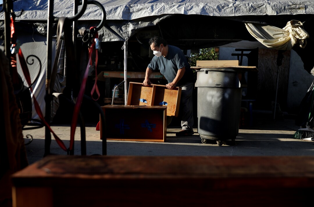 Mario Alarcon restores an antique dresser for a client.