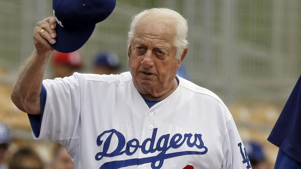 Former Dodgers manager Tommy Lasorda acknowledges fans before a spring training game in Glendale, Ariz., on March 3, 2013.