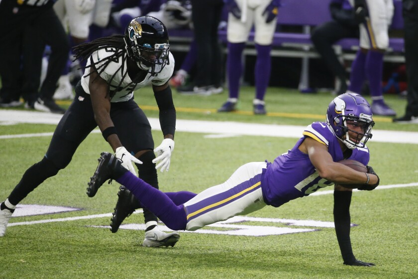 Minnesota Vikings wide receiver Justin Jefferson, right, dives for extra yardage ahead of Jacksonville Jaguars cornerback Tre Herndon, left, during the second half of an NFL football game, Sunday, Dec. 6, 2020, in Minneapolis. (AP Photo/Bruce Kluckhohn)