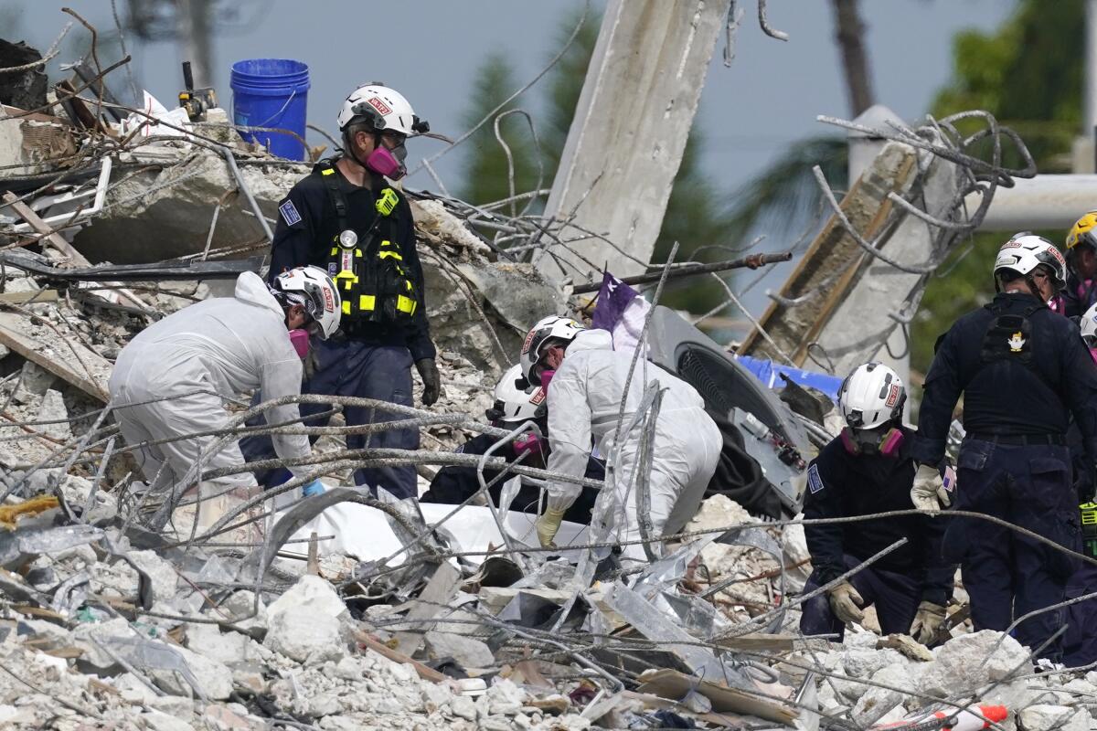 Rescue handling tarp in condo tower rubble