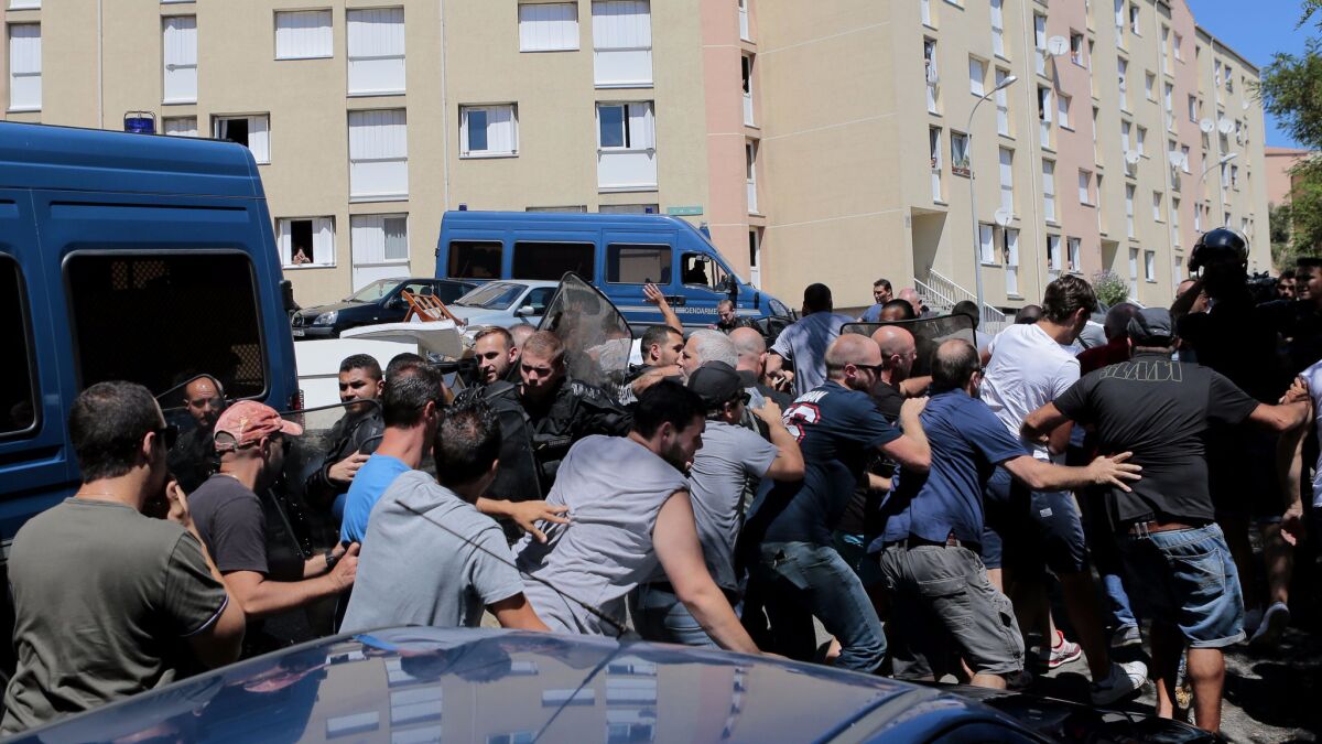 People gather in the Lupino neighborhood of Bastia to demonstrate the day after a fight over tourists taking pictures of women in "burkinis" left five injured on the island of Corsica.