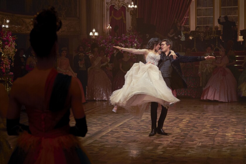 A woman in a ball gown and a man in a suit dance