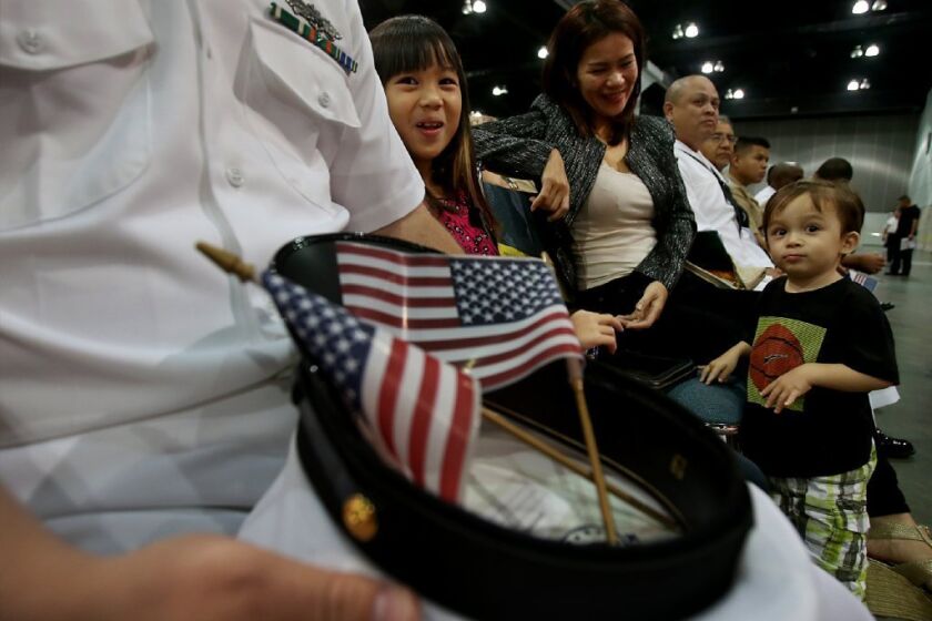 An immigrant from the Philippines waits with her children before the start of a naturalization ceremony in Los Angeles last year.