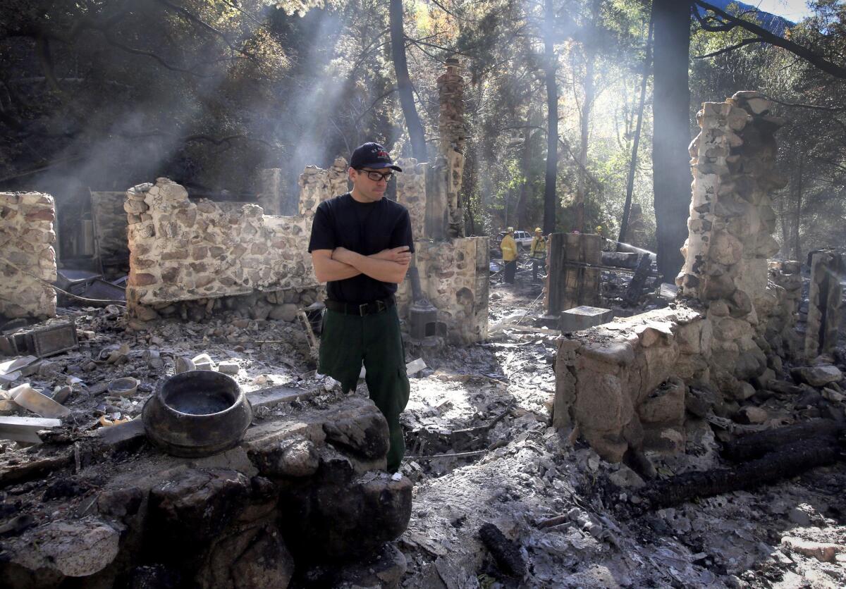 Canyon resident Daniel Fitzgerald walks through the rubble of his neighbor's cabin, which he helped to build and restore, in West Horsethief Canyon off Trabuco Creek Road.