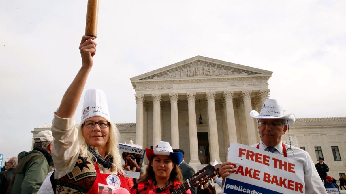 Mary Torres holds up a rolling pin in support of cake artist Jack Phillips outside the Supreme Court in Washington on Dec. 5.
