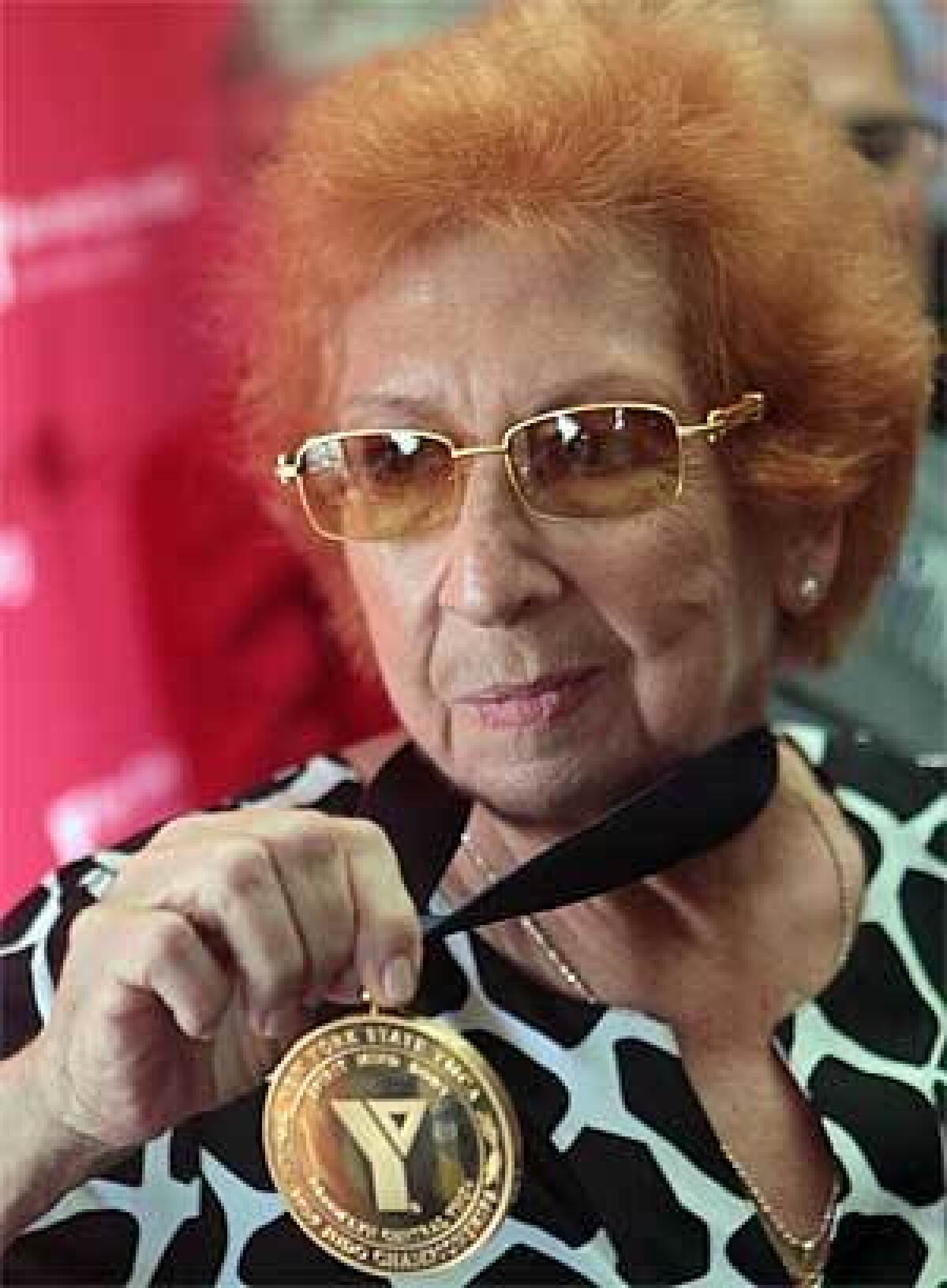 Kanokogi shows her gold medal for the 1959 New York State YMCA Judo Championships. Fifty years earlier she was stripped of the gold medal in the competition after judges realized she was a woman fighting against men.