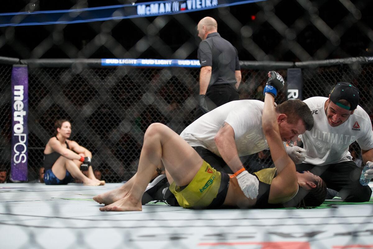 Ketlen Vieira is embraced by her team members after defeating Sara McMann, left, during their fight at UFC 215.