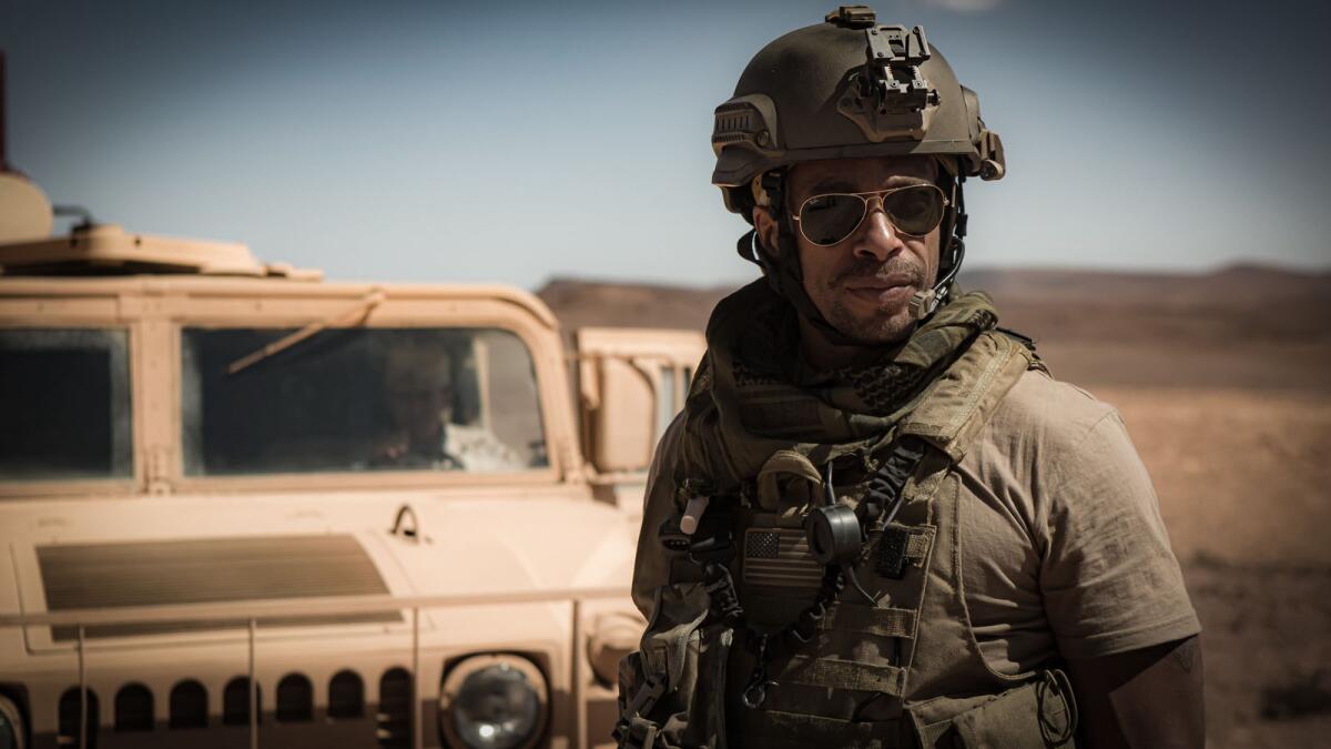 Gary Dourdan wears a military helmet near a vehicle in the movie "Redemption Day."
