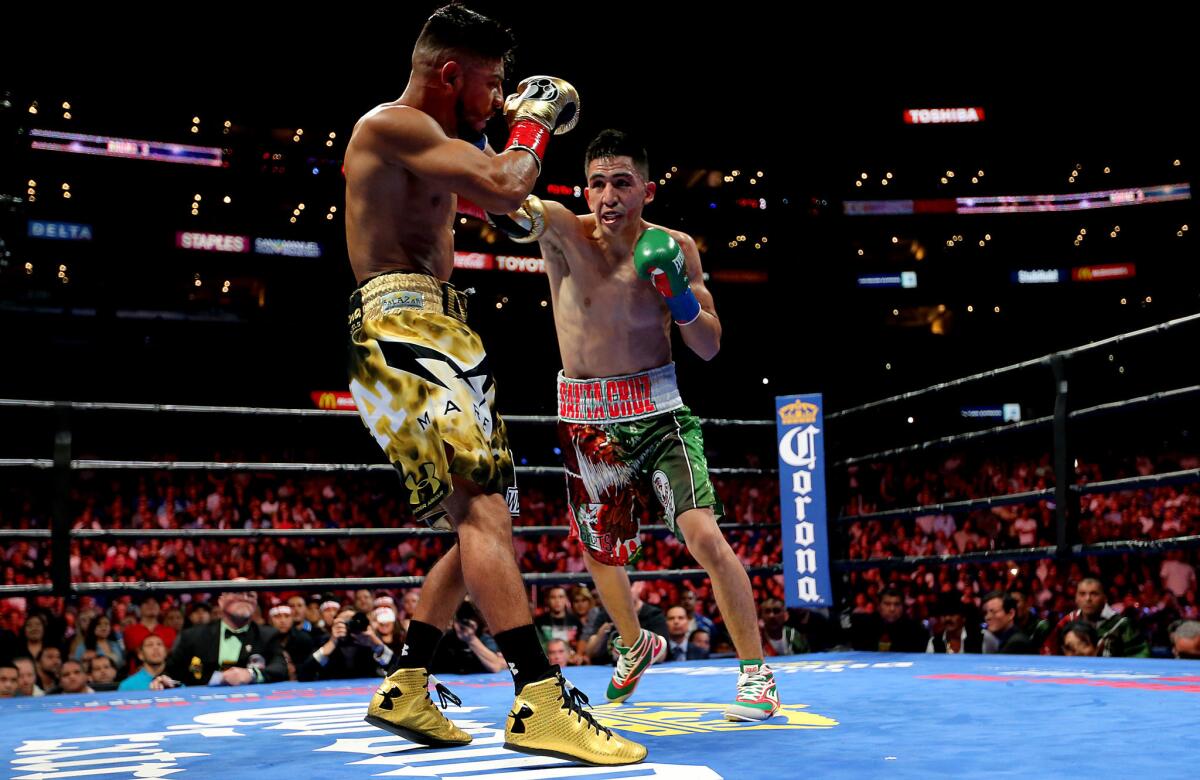 Leo Santa Cruz, right, exchanges punches with Abner Mares in their featherweight fight on Aug. 29, 2015, at Staples Center.